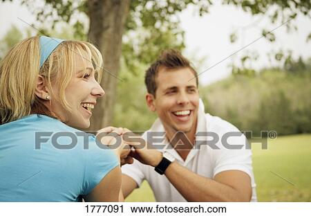 A young couple holding hands in the park View Large Photo Image Stock Image - A young couple holding hands in the park. Fotosearch