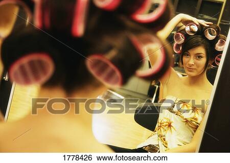 A young woman admiring herself in a mirror View Large Photo Image Stock Photograph - A young woman admiring herself in a mirror. Fotosearch