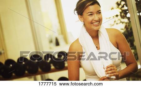A young woman in a fitness facility smiling View Large Photo Image Stock Photography - A young woman in a fitness facility smiling. Fotosearch