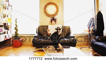 A young woman waiting at a salon with rollers in her hair View Large Photo Image Stock Image - A young woman waiting at a salon with rollers in her hair. Fotosearch