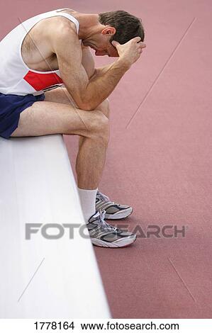 Picture - Athlete resting on bench. Fotosearch