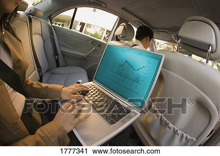 Businesswoman in a car working on a laptop View Large Photo Image Stock Image - Businesswoman in a car working on a laptop. Fotosearch