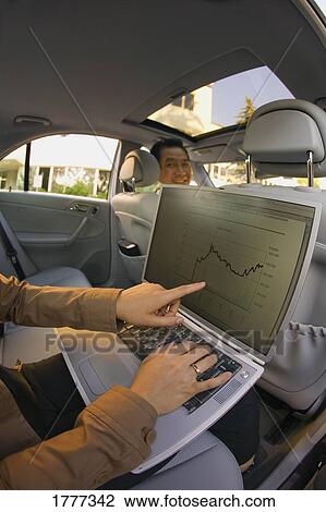 Businesswoman on a laptop in a car View Large Photo Image Stock Image - Businesswoman on a laptop in a car. Fotosearch