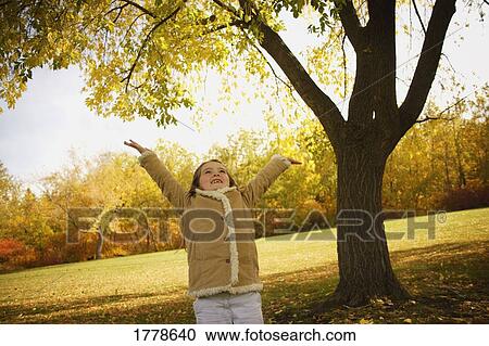 Child tries to catch falling leaves View Large Photo Image Stock Image - Child tries to catch falling leaves. Fotosearch