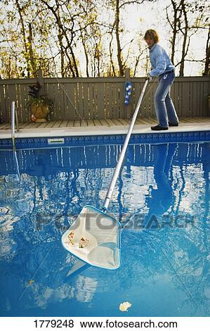 Cleaning leaves out of the pool View Large Photo Image Stock Photo - Cleaning leaves out of the pool. Fotosearch