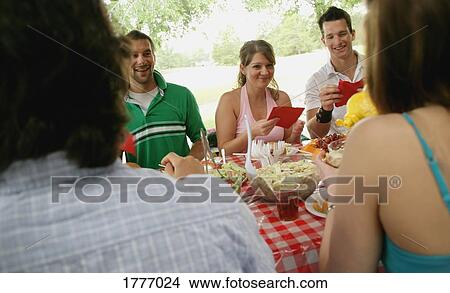 Friends having a picnic in the park View Large Photo Image Picture - Friends having a picnic in the park. Fotosearch