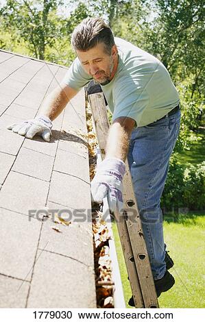 Man does maintenance on his eaves View Large Photo Image Stock Image - Man does maintenance on his eaves. Fotosearch