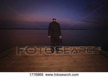 Man looking down over dark water View Large Photo Image Stock Photograph - Man looking down over dark water. Fotosearch