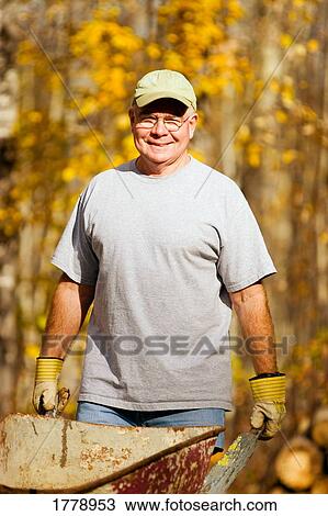 Man with a wheelbarrow View Large Photo Image Stock Image - Man with a wheelbarrow. Fotosearch