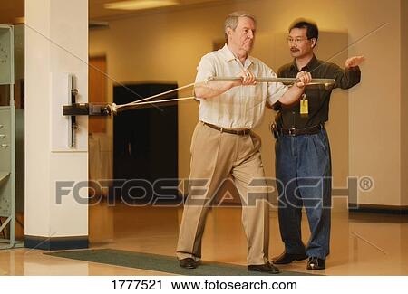 Stock Image - Occupational therapist working with a senior businessman. Fotosearch