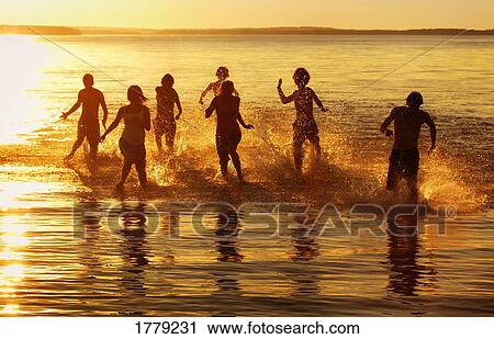 Stock Image - People running in the water. Fotosearch
