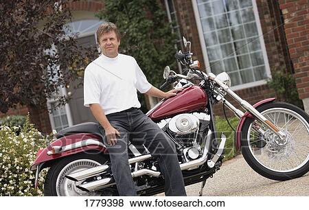 Stock Photo - Portrait of a man with his motorcycle. Fotosearch