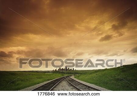 Rail tracks and a distant city View Large Photo Image Stock Photograph - Rail tracks and a distant city. Fotosearch