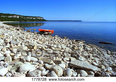 Stock Photo - Shoreline Lake and Red Canoe. Fotosearch