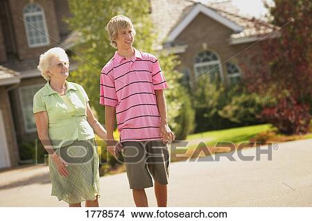 Teenager walks with grandmother View Large Photo Image Picture - Teenager walks with grandmother. Fotosearch