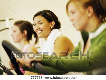 Stock Image - Three young women exercising. Fotosearch