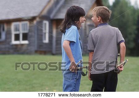 Stock Image - Two boys with slingshots. Fotosearch
