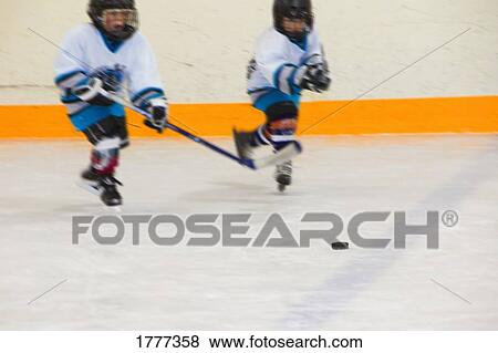 Stock Photo - Two junior hockey players on the ice. Fotosearch
