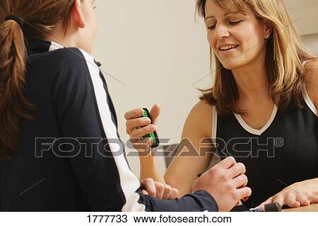 Stock Image - Two women observing an object. Fotosearch