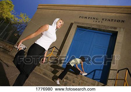 Two women stretching View Large Photo Image Stock Image - Two women stretching. Fotosearch