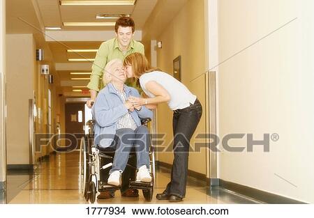 Two young adults visiting a senior woman in the hospital View Large Photo Image Picture - Two young adults visiting a senior woman in the hospital. Fotosearch