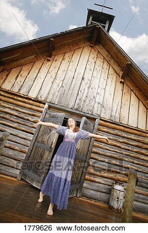 Woman comes out of chapel with arms raised View Large Photo Image Stock Photograph - Woman comes out of chapel with arms raised. Fotosearch