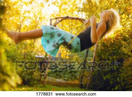 Stock Image - Woman swinging on swing. Fotosearch