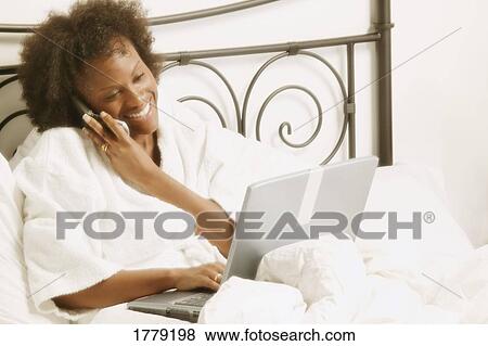 Woman works in bed View Large Photo Image Stock Photo - Woman works in bed. Fotosearch