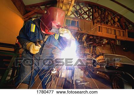 Stock Photo - A welder working in a shop. Fotosearch