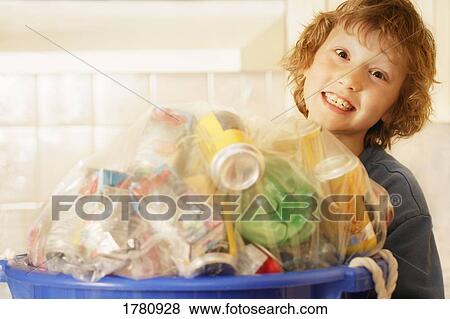 Stock Photo - Boy holding bottles to be recycled. Fotosearch