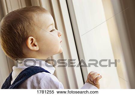 Stock Photography - Child looks out the window. Fotosearch