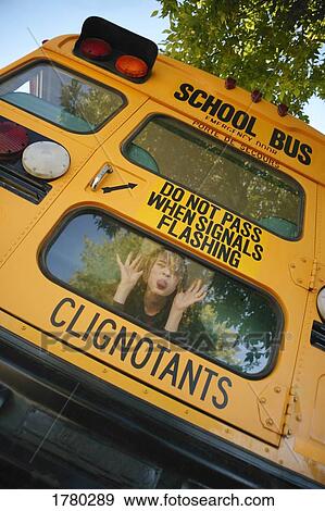 Stock Photo - Child makes faces on school bus. Fotosearch