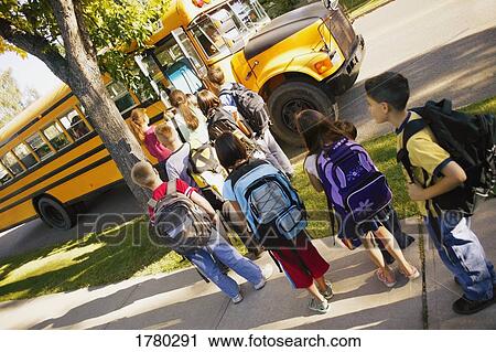 Stock Image - Children line up to board school bus. Fotosearch