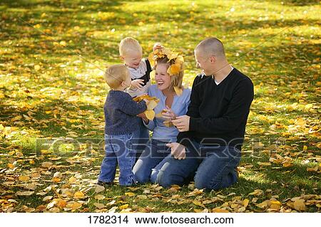 Picture - Children sprinkle leaves on mom. Fotosearch