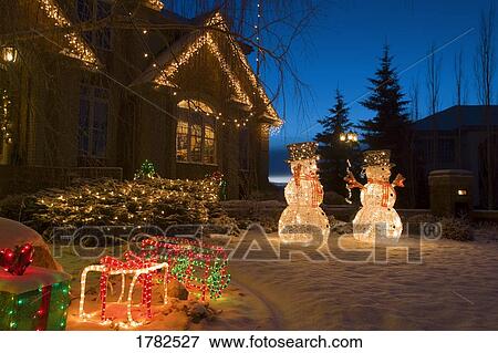 Stock Photo - Christmas lights and snowmen outside house. Fotosearch