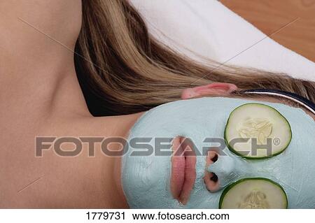 Stock Image - Closeup of a woman with a facial masque. Fotosearch