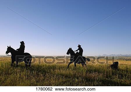 Stock Image - Cowboys on their horses. Fotosearch