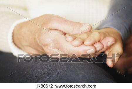 Stock Image - Inter-generational couple holding hands. Fotosearch