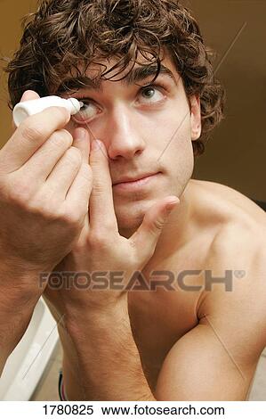 Stock Photography - Man applying eye drops. Fotosearch