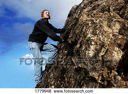 Stock Photo - Man climbs mountain. Fotosearch