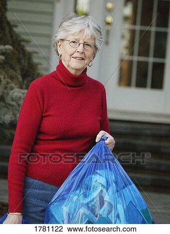 Stock Image - Older lady recycling. Fotosearch