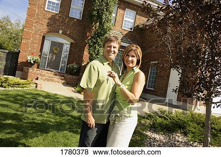 Portrait of a couple in front of their home View Large Photo Image Stock Photo - Portrait of a couple in front of their home. Fotosearch