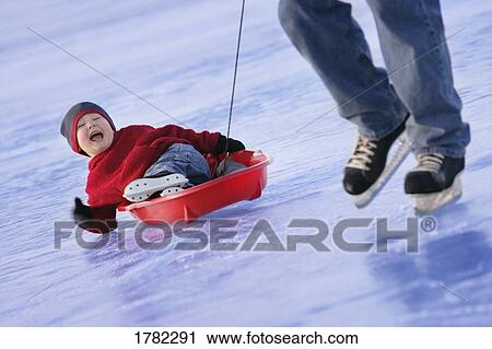 Stock Image - Pulling child on the ice. Fotosearch