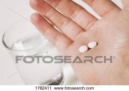 Stock Image - Taking two pills. Fotosearch