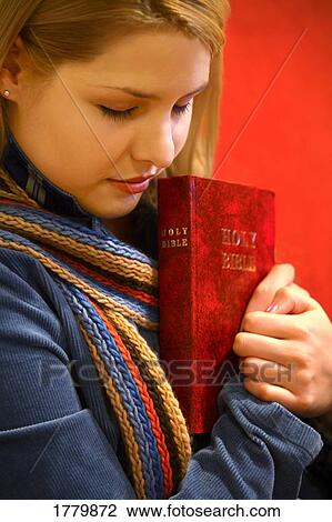 Teen holds Bible and prays View Large Photo Image Stock Image - Teen holds Bible and prays. Fotosearch