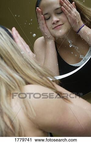 Stock Image - Washing her face. Fotosearch