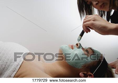 Woman applies a facial masque View Large Photo Image Stock Photo - Woman applies a facial masque. Fotosearch