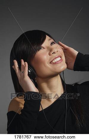 Stock Photo - Woman listening with headphones. Fotosearch