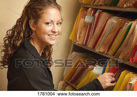 Picture - Woman looking through files. Fotosearch
