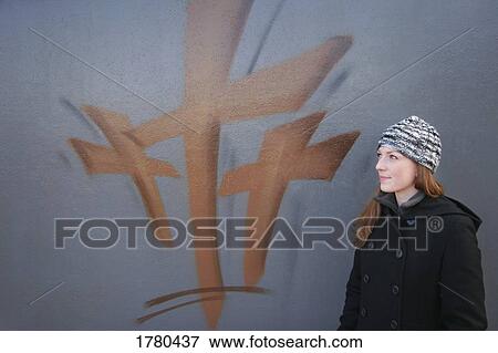 Stock Photo - Woman stands by painting of the cross. Fotosearch